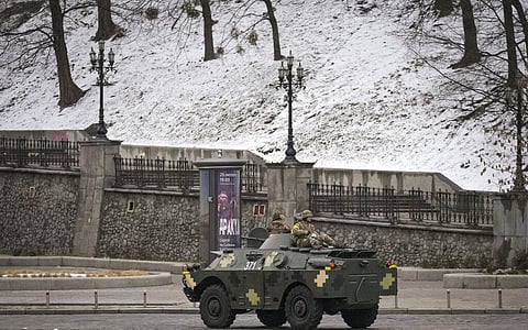 Ukrainian servicemen ride on top of an armored personnel carrier speeding down a deserted boulevard during an air raid alarm, in Kyiv, Ukraine. (Photo | AP)