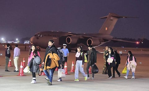 Indian nationals walk after deboarding from an IAF plane with evacuated people from war hit Ukraine, upon its arrival at Hindan in Ghaziabad, Thursday, March 10, 2022. (Photo | PTI)