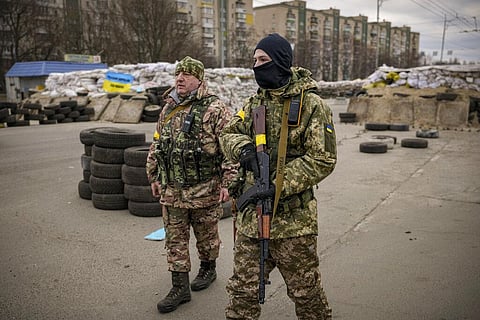 A Ukrainian serviceman has 'Mommy' written on his weapon strap as he stands guard at a checkpoint on a main road in Kyiv, Ukraine, Monday, March 7, 2022. (Photo | AP)