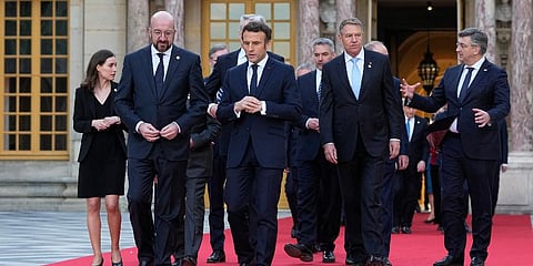 French President Emmanuel Macron, center, speaks with European Council President Charles Michel, center left, as they walk at an EU summit at the Chateau de Versailles, Mar 10, 2022. (Photo | AP)
