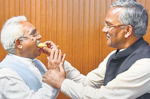 Former Uttarakhand CM Trivendra Singh Rawat (R) with state BJP president Madan Kaushik in Dehradun on Friday. (Photo | Special Arrangement)