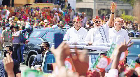 Prime Minister Narendra Modi waves at BJP supporters during a roadshow in Ahmedabad on Friday. (Photo | PTI)