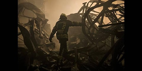 A Ukrainian firefighter walks inside a large food products storage facility which was destroyed by an airstrike on March 13,2022(Photo | AP)