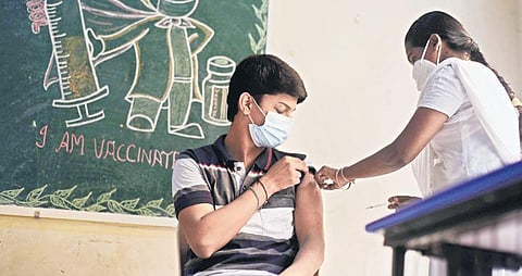 A health worker inoculates a boy against Covid-19 during a vaccination drive for students of private schools at Mylapore, in Chennai  | R Satish Babu