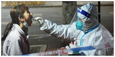 A medical worker takes swab sample from a resident for COVID-19 test in Hangzhou in eastern China's Zhejiang province Tuesday, March 15, 2022. (photo | AP)