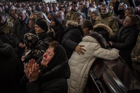Relatives and friends attend a funeral ceremony for four of the Ukrainian military servicemen, who were killed during an airstrike in a military base in Yavoriv, in a church in Ukraine. (AP Photo)