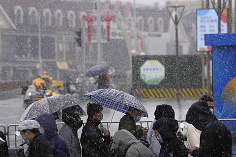 Residents line up for COVID-19 test as it snows on Thursday, March 17, 2022, in Beijing. (Photo |AP)