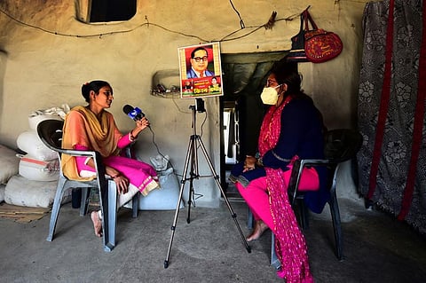 Senior journalist Geeta Devi (right) interviews a woman who was abandoned by her husband. (Photo | AFP)