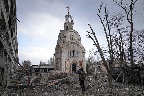 A Ukrainian serviceman takes a photograph of a damaged church after shelling in a residential district in Mariupol, Ukraine. (Photo | AP)
