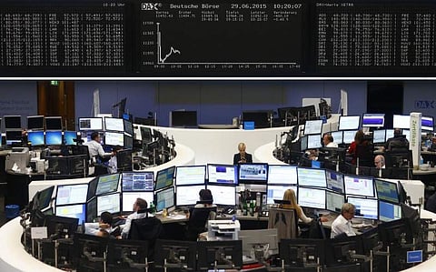Traders sit at their desks in front of the DAX board at the Frankfurt stock exchange, Germany.(REUTERS)