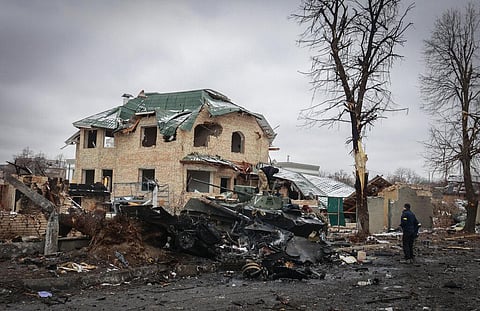 A man looks at the gutted remains of Russian military vehicles on a road in the town of Bucha, close to the capital Kyiv, Ukraine. (Photo | AP)