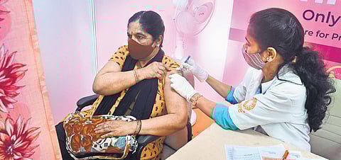 A health worker administers a booster dose to a woman, in Bengaluru | Express