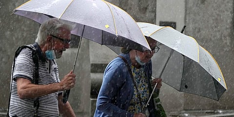 Pedestrians use umbrellas to shield the rain in Sydney. (Photo| AP)