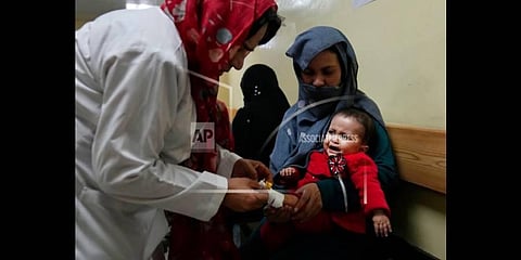 An Afghan woman holds her sick daughter, as a nurse treats her in the malnutrition ward of the Indira Gandhi Children's Hospital, in Kabul, Afghanistan, Thursday, Feb. 24, 2022.(Photo | AP)
