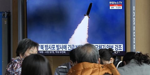 People stand by a TV screen showing a file image of North Korea's rocket launch during a news program, at the Seoul Railway Station in Seoul, South Korea, Sunday, March 20, 2022.(AP Photo)