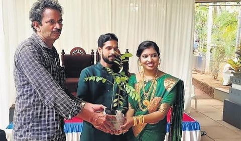 Raghavan handing over a sapling to a newly-wed couple | Express