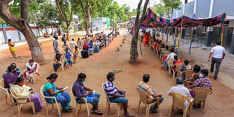 People wait to receive the token for Covid-19 vaccine at the Ramanathapuram health care centre. (Photo | PTI)