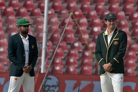 Pakistan's Babar Azam, left, and Australia's Pat Cummins wait for the coin toss on the 1st day of the third test match between Pakistan and Australia at the Gaddafi Stadium in Lahore. ( Photo | AP)