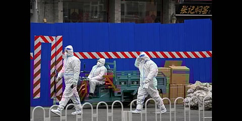 Security guards wearing protective gear patrol near a barricaded community locked down for health monitoring following a COVID-19 case detected in the area,  March 22, 2021, in Beijing(Photo | AP)