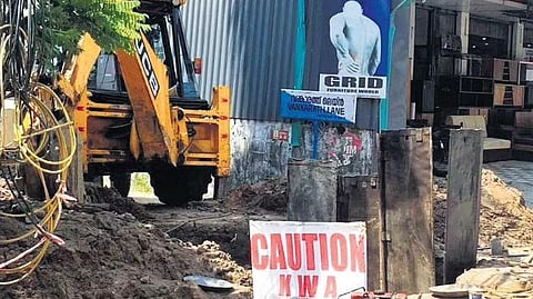 KWA using an earthmover to dig up a road passing through a residential area  at Palarivattom | Express
