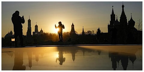 A woman poses for a photo during sunset over the Kremlin at Zaryadye Park near Red Square in Moscow, Russia. (Photo |AP)a