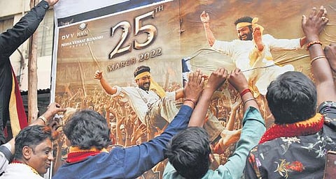 Members of Kannada organisations tear posters of the Telagu movie  RRR at Anupama Theatre in Bengaluru on Thursday