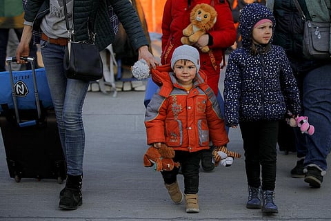 A refugee fleeing the war from neighbouring Ukraine walks with children holding toys after crossing the border by ferry at the Isaccea-Orlivka border crossing in Romania. (Photo | AP)