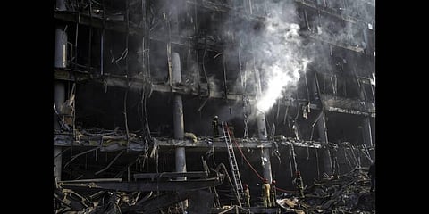 Firefighters try to extinguish a fire amid the destruction caused after shelling of a shopping center, in Kyiv, Ukraine. (Photo | AP)