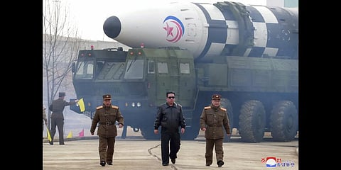 In this photo distributed by the North Korean government,Kim Jong Un, center, walks around what it says a Hwasong-17 intercontinental ballistic missile (ICBM) on the launcher.(Photo | AP)