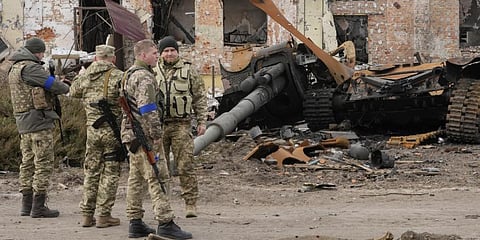 Ukrainian soldiers watch debris from a Russian tank after recent fights in the town of Trostsyanets.(Photo | AP)