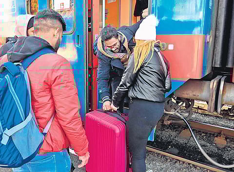 An Indian student helps a woman onto a train near the Hungary-Ukraine border;