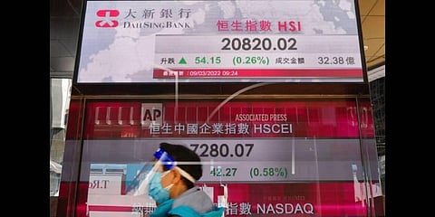 A man walks past a bank's electronic board showing the Hong Kong share index at Hong Kong Stock Exchange(File Photo |AP)