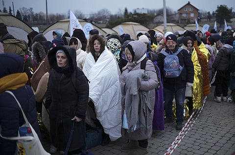 Refugees wait in a crowd for transportation after fleeing from the Ukraine and arriving at the border crossing in Medyka, Poland. (File Photo | AP)