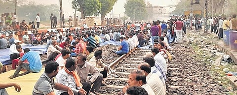 Agitators squatting on the tracks at Bamra railway station on Wednesday. ( Photo | EPS)