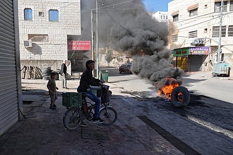 Burning tires block the entrance of the Palestinian village of Burqin, west of Jenin, in the Israeli occupied West Bank on September 26, 2021. (File Photo | AFP)