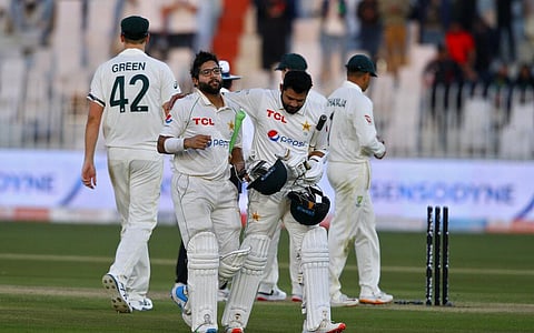 Pakistan's Azhar Ali, center right, congratulates teammate Imam-ul-Haq, while they walk back to pavilion on the end of the play of 1st day of first cricket test match . (Photo | AP)
