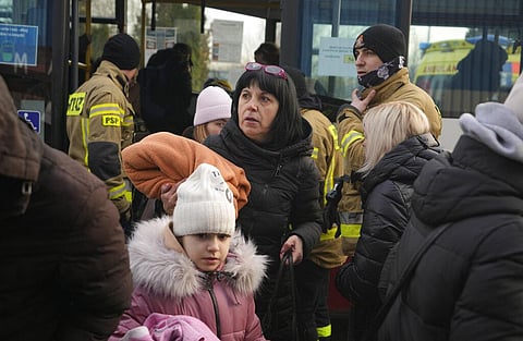 A woman and her child come out of a station in Mlyny, near the Korczowa border crossing, in Poland, Thursday, March 3, 2022. (Photo | AP)