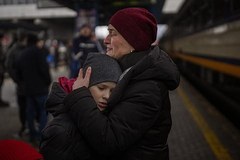 Tanya, 38, cries with her son Bogdan, 10, before getting a train to Lviv at the Kyiv station, Ukraine, Thursday, March 3, 2022. (AP Photo)