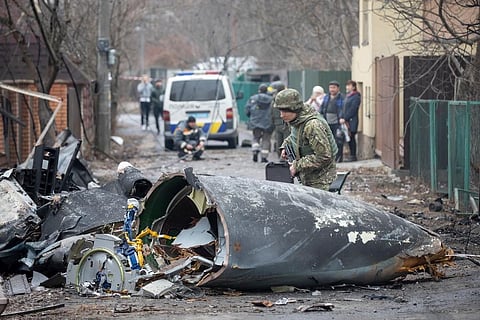 A Ukrainian Army soldier inspects fragments of a downed aircraft in Kyiv, Ukraine. ( Photo | AP)