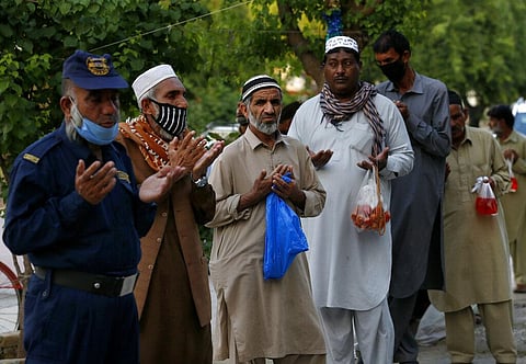 People pray before receiving free food for breaking their fast during Ramzan. (Photo for representational purpose only| AP)
