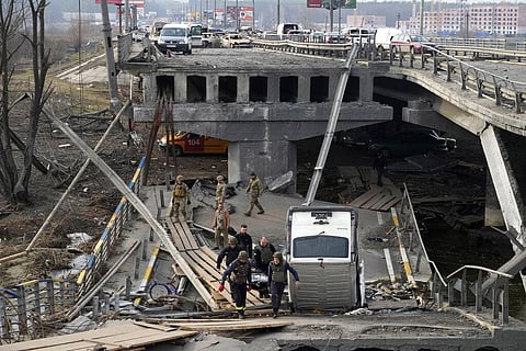 Ukrainian soldiers carry a body of a civilian killed by the Russian forces over the destroyed bridge in Irpin close to Kyiv, Ukraine, Thursday, March 31, 2022(Photo |AP)