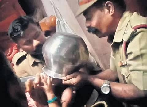 Fire service personnel removing a vessel stuck on the head of a child at Sathya Nagar in Padi | Express