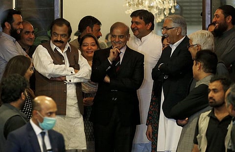 Pakistan's opposition leader Shahbaz Sharif, center, is surrounded by his aids smiles prior to a press conference following the Supreme Court decision, in Islamabad. (Photo | AP)