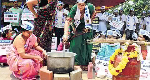 Aam Aadmi Party Women’s Wing cook food on wood fire to protest against rising prices of cooking gas and fuel at Freedom Park on Saturday. Around 250 AAP leaders and volunteers joined the agitation aro