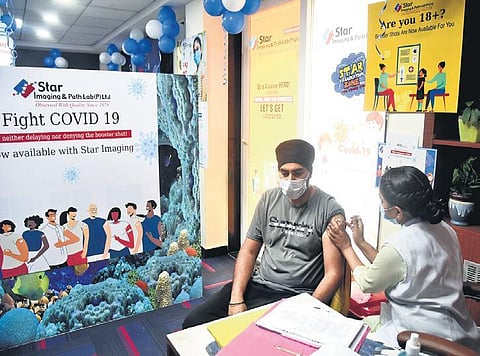 A health worker inoculates a man with Covaxin in Delhi | express