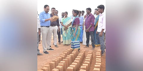 Officials examine a brick from a fresh batch made by the labourers in Tiruttani.