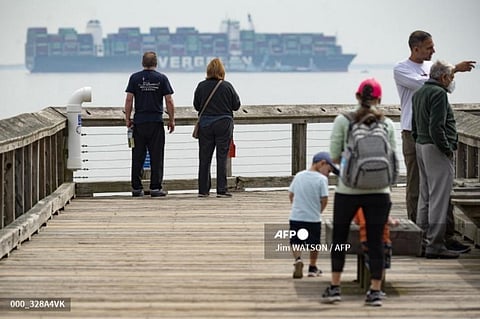 Onlookers at Downs Park in Pasadena, watch as cranes take containers off the Ever Forward container ship as it sits in Chesapeake Bay. (Photo | AFP)