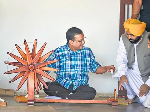 Delhi CM Arvind Kejriwal and Punjab CM Bhagwant Mann spin thread on a ‘charkha’ during their visit to the Sabarmati Ashram reently. (File Photo| PTI )