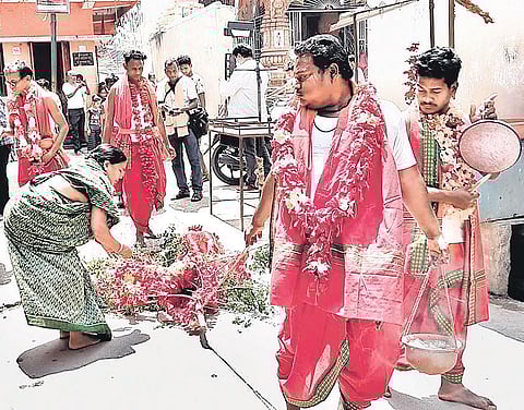 Priests dragging a branch of neem tree through a lane in Bargarh town | Express
