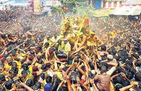 Devotees spray water on Lord Kallazhagar during the theerthavari ritual in Madurai on Saturday | k k sundar